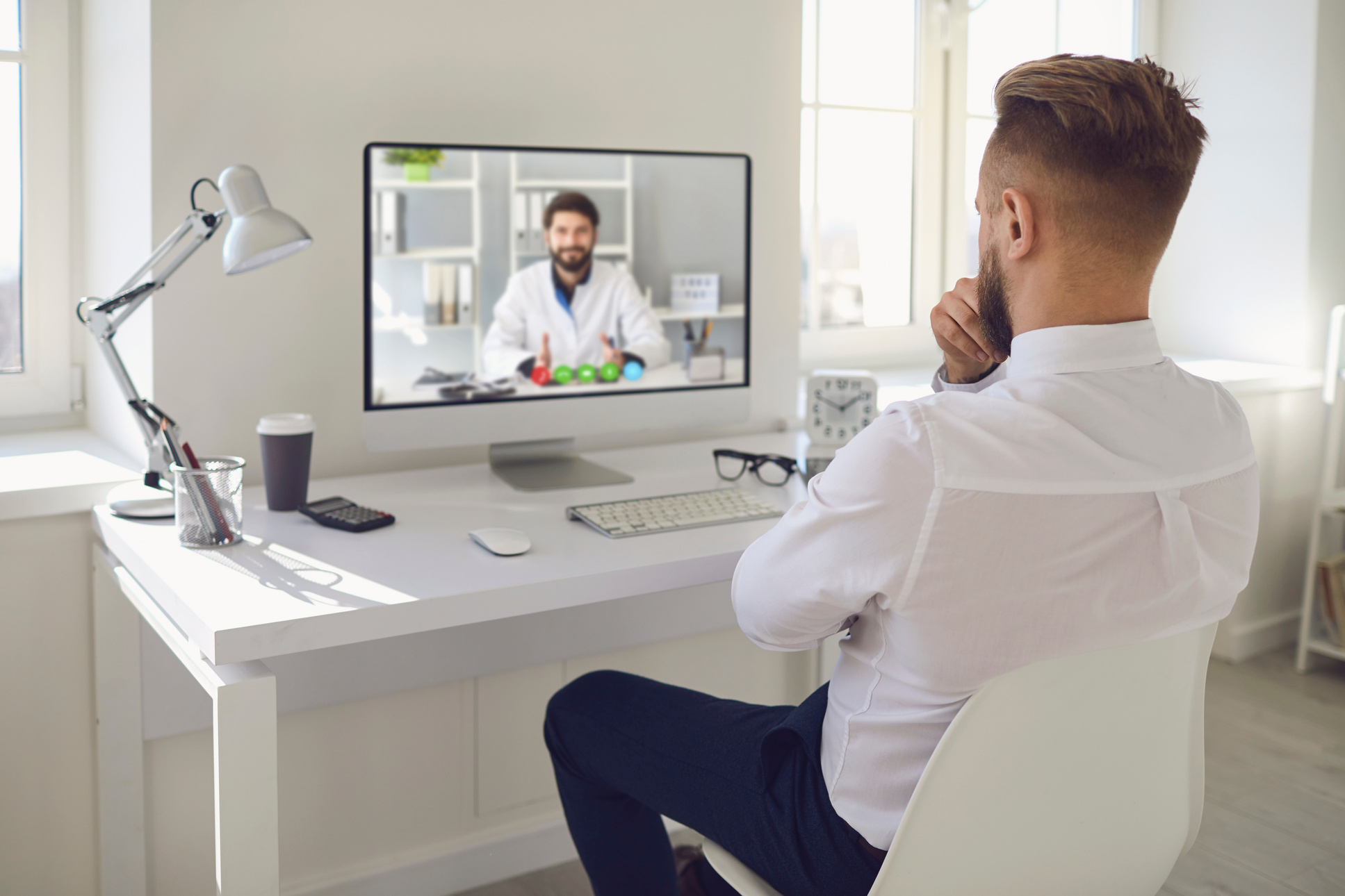 Online Doctor.a Man Talking to a Doctor Online on a Computer on a Desk in an Office. Online Medical Consultation.